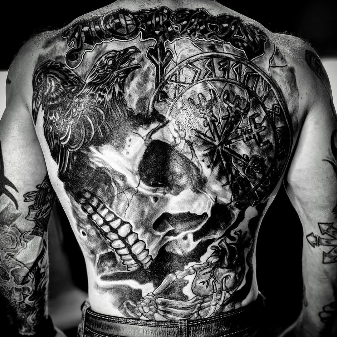 Adult man working with tattoo pen on arm